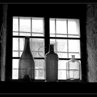 Okenní zátiší s flaškami.
